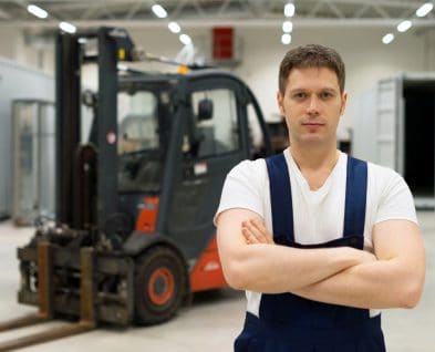 Handsome forklift operator in the warehouse.