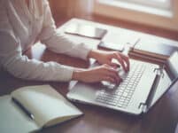Woman working in home office hand on keyboard close up