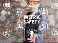 Work Safety First Standard Сonstruction Industry Business Concept. Health Protection, Personal Security People On Job, Hazards, Regulations. Man In Helmet Presenting Work Safety Icon On Virtual Screen