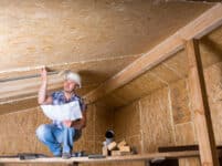 Builder reading plans inside unfinished home