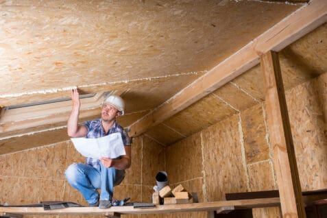 Builder reading plans inside unfinished home